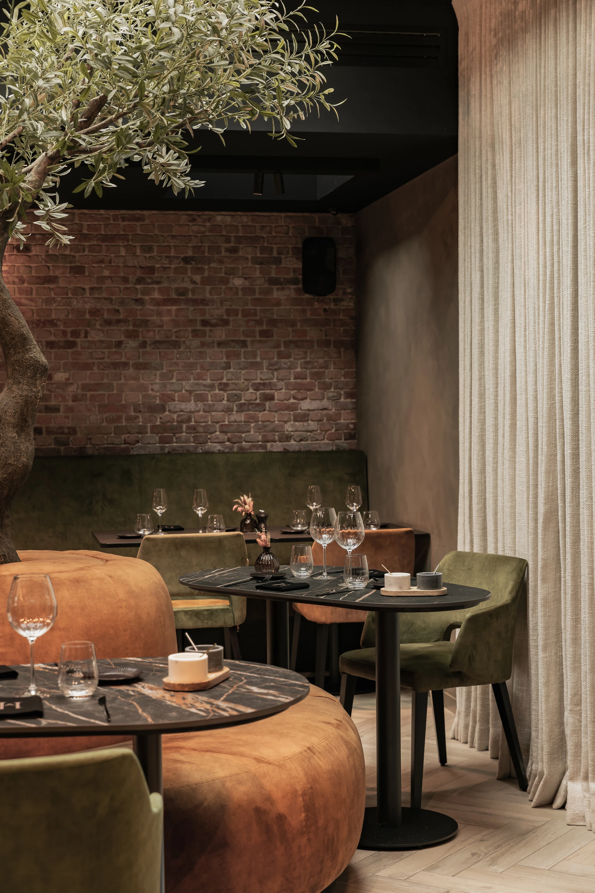 Sfeerbeeld van tafels rond de boom in Restaurant Herenhuis Izegem